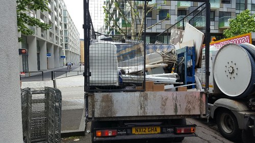 Commercial skip being loaded with construction debris